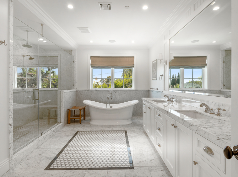 Bathroom with large walk-in shower with seating, soaker tub, window and large double vanity. Marble and grey and white tile