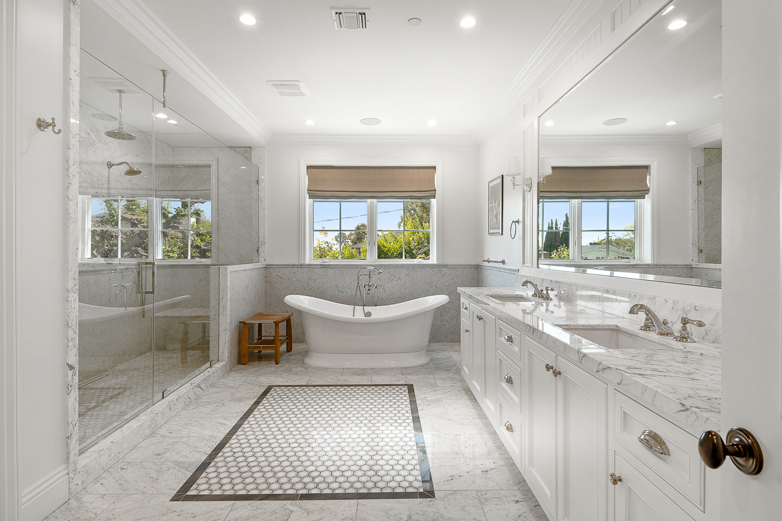 Bathroom with large walk-in shower with seating, soaker tub, window and large double vanity. Marble and grey and white tile