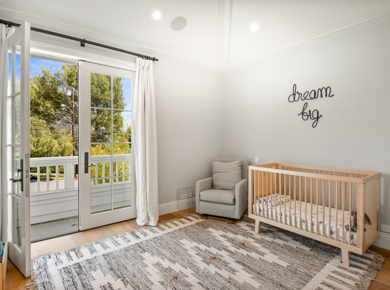 Child's bedroom with crib and French doors opening to balcony