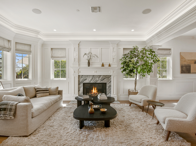 Large living room area with marble fireplace and crowned molding, vaulted ceiling