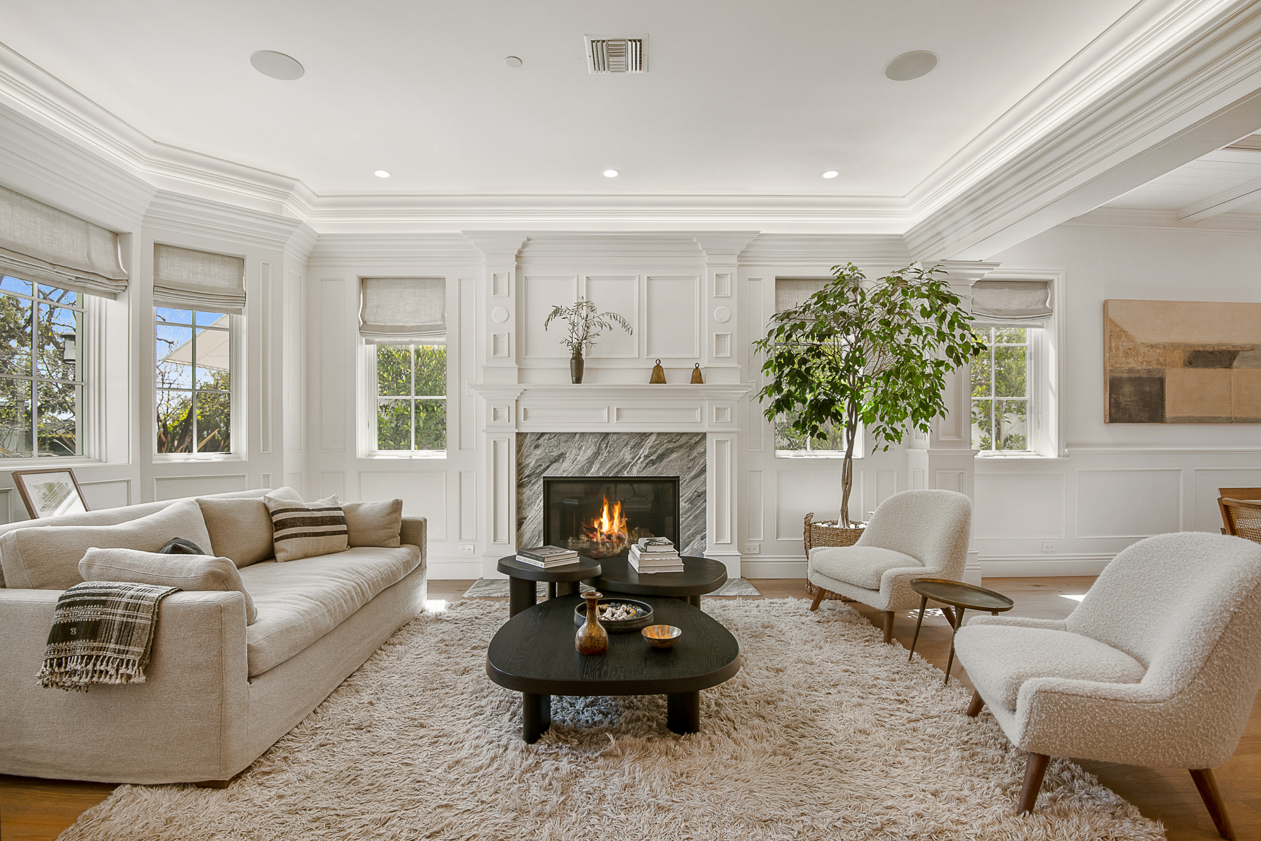 Large living room area with marble fireplace and crowned molding, vaulted ceiling