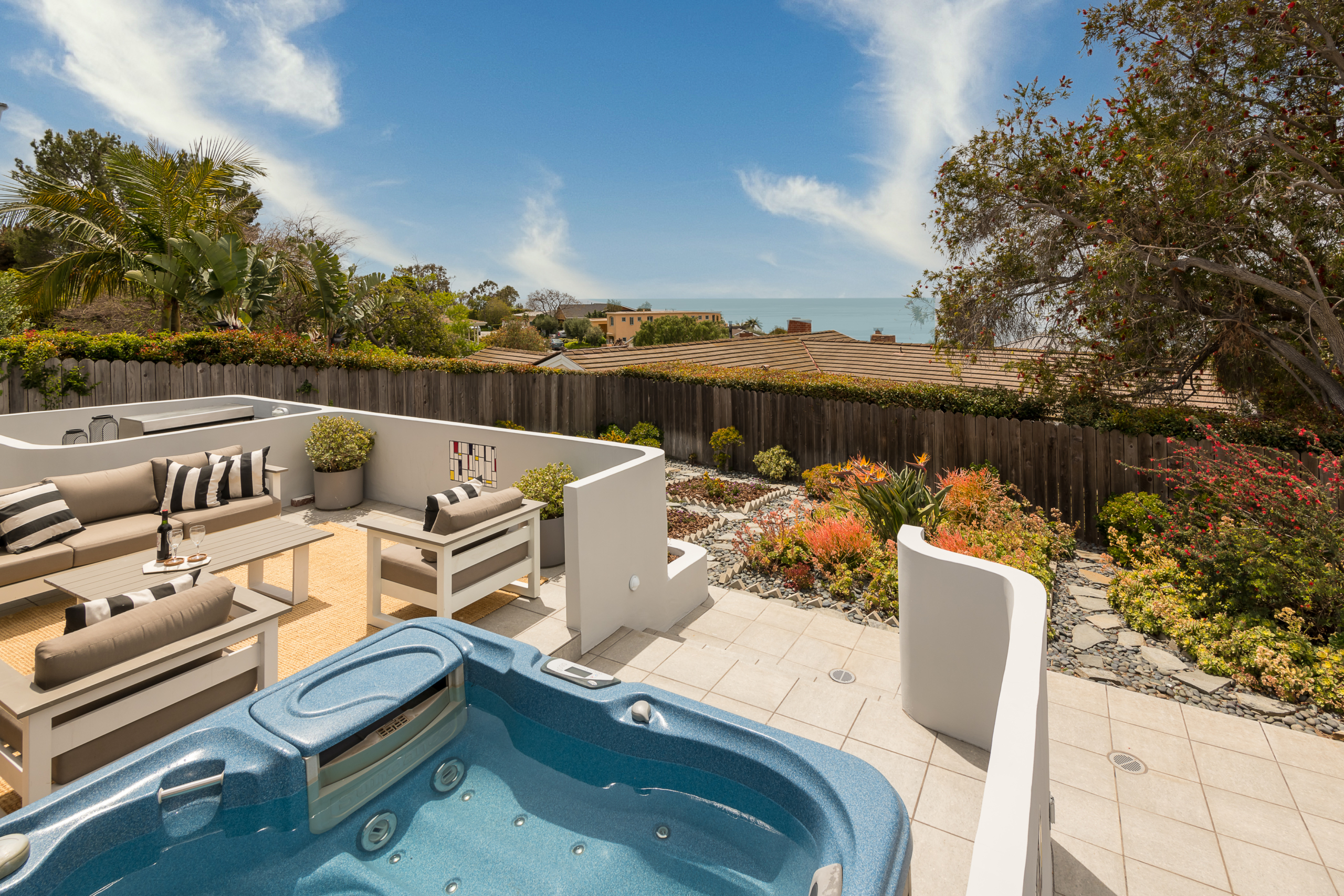 Patio entertaining area, hot tub and garden with view of ocean