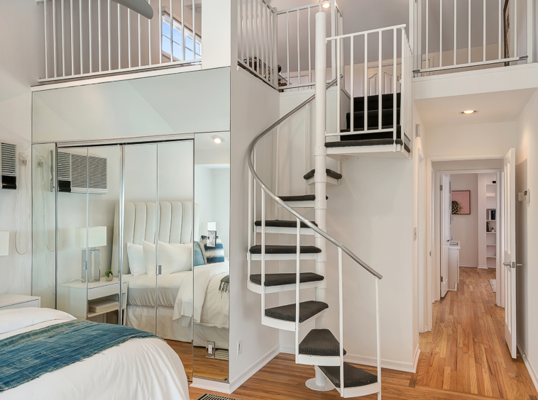 Spiral staircase leading to second level from bedroom