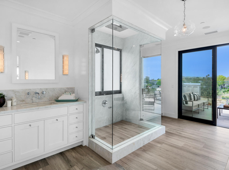 Vanity and walk-in shower with view of balcony