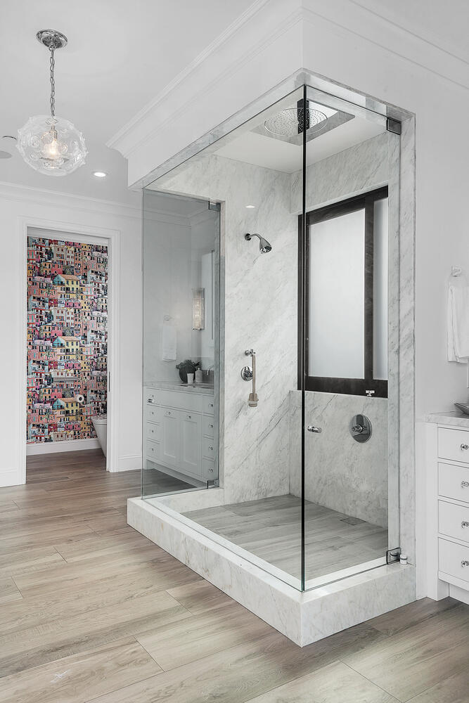 bright bathroom with large walk-in glass shower and light flooring