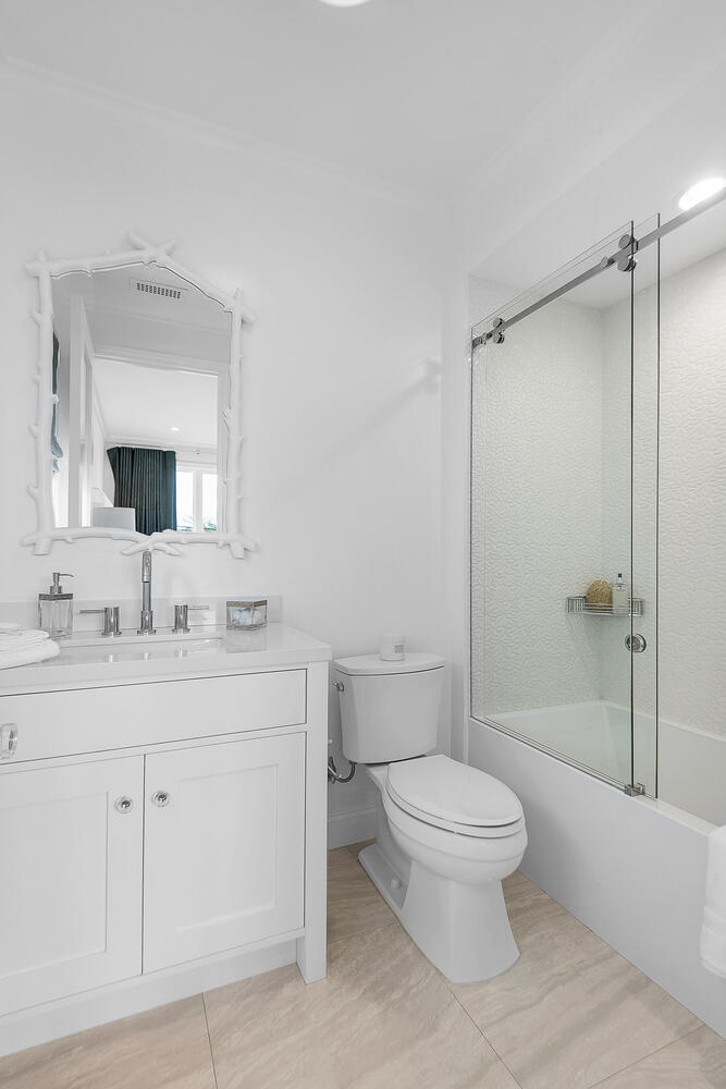 Mostly white bathroom with vanity and shower/tub combo