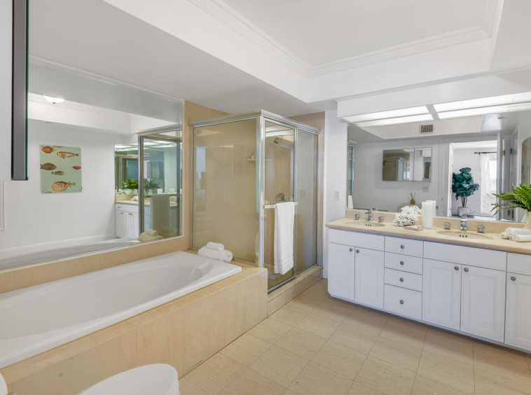 Large bathroom with light tile and two-sink vanity, walk-in shower and soaker bathtub