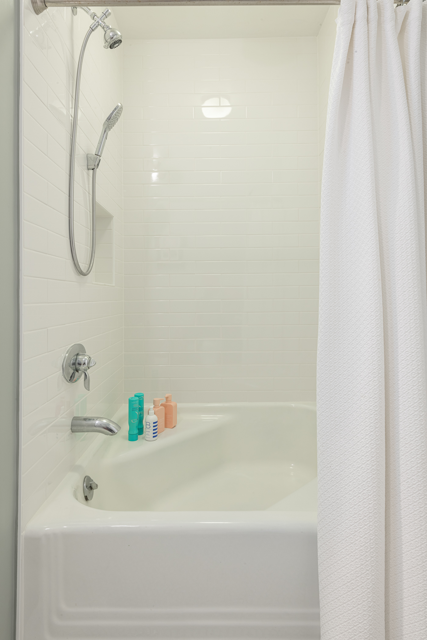 White tiled bathroom shower and tub