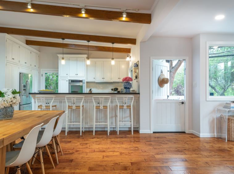 Bright dining room and kitchen with wood exposed beams and hand hewn floor