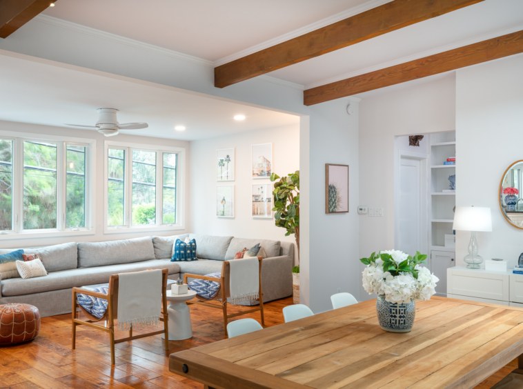 Bright dining and living room with wood exposed beams and hand hewn floor