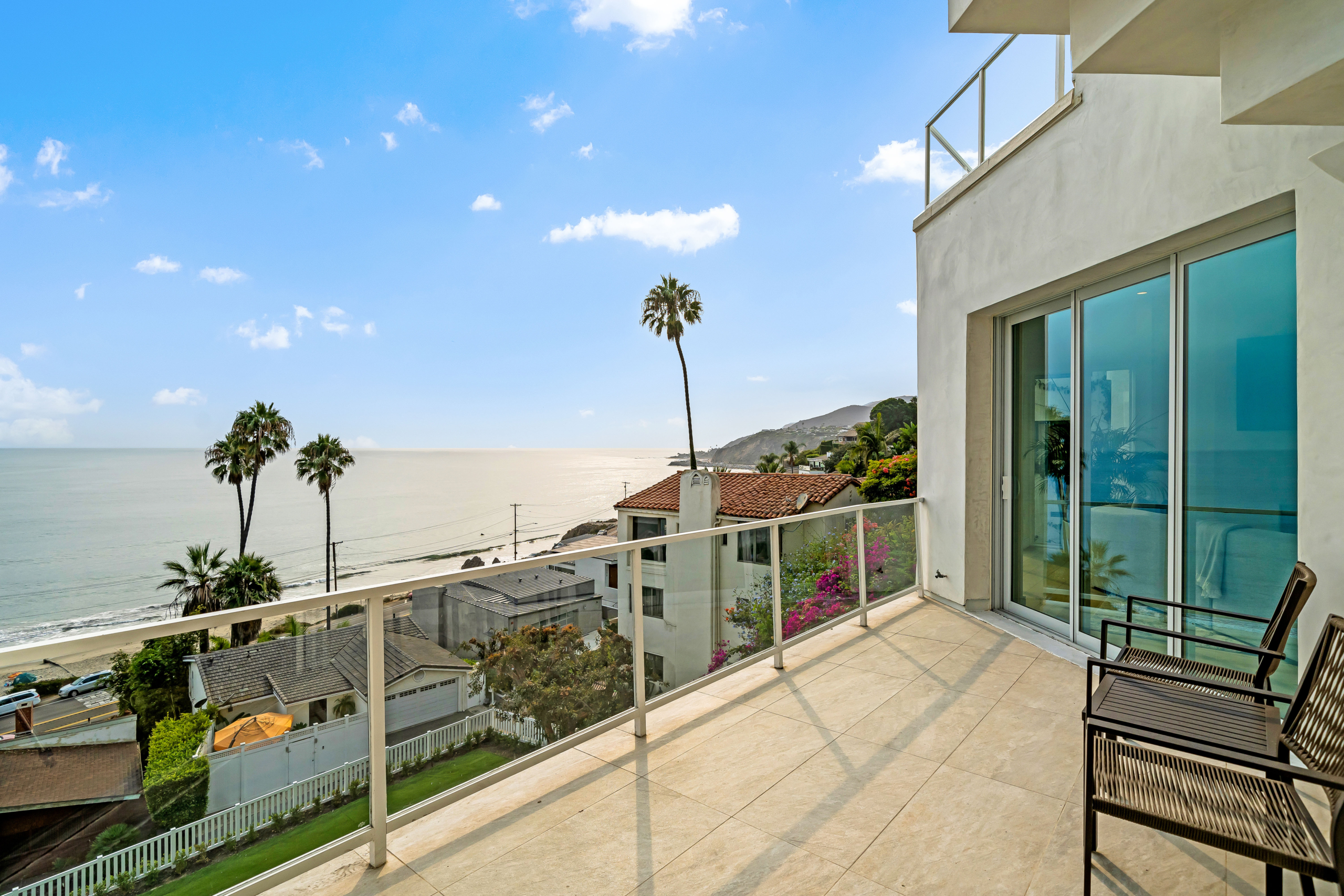 balcony with wide view of neighboring homes below and view of the ocean