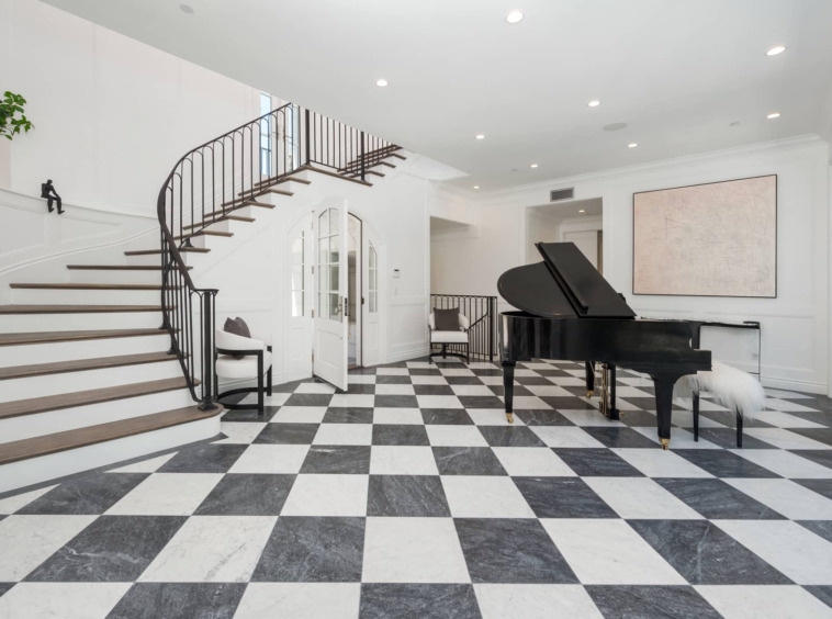 Foyer featuring black and white tile with piano and grand staircase