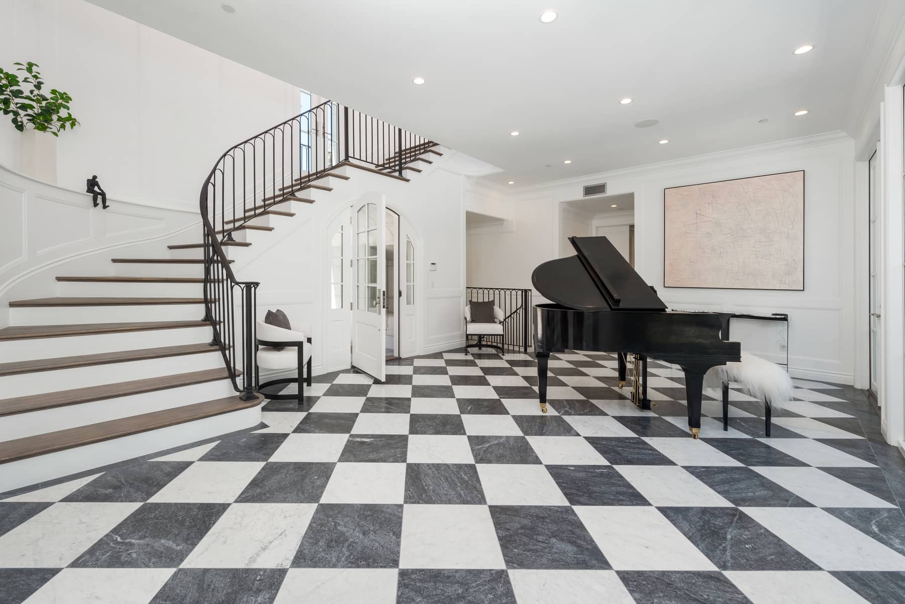 Foyer featuring black and white tile with piano and grand staircase