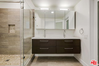 bathroom with floating vanity, mirrored medicine cabinets and big walk-in shower