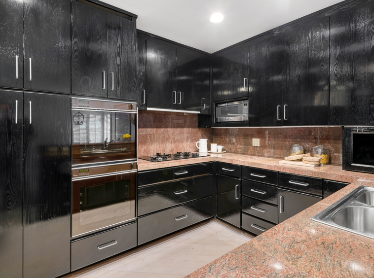 kitchen with predominantly black cabinets with granite countertops