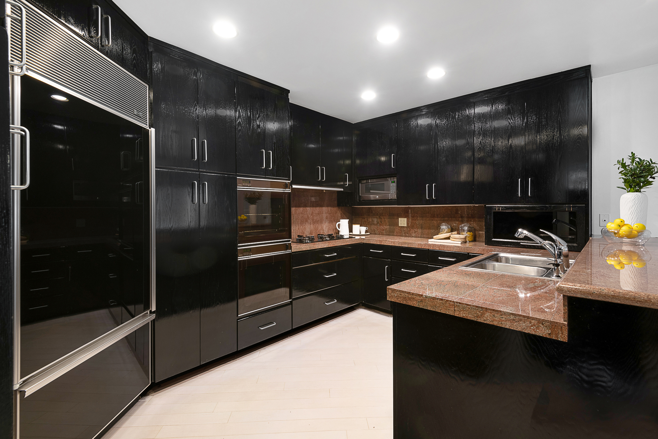 kitchen with predominantly black cabinets with granite countertops