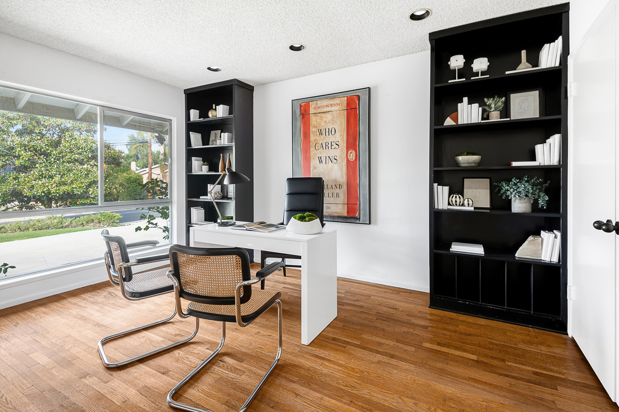 Office with Black book shelves and hardwood flooring