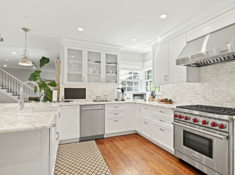 Modern white litchen with whote and grey granite and upscale stainless appliances