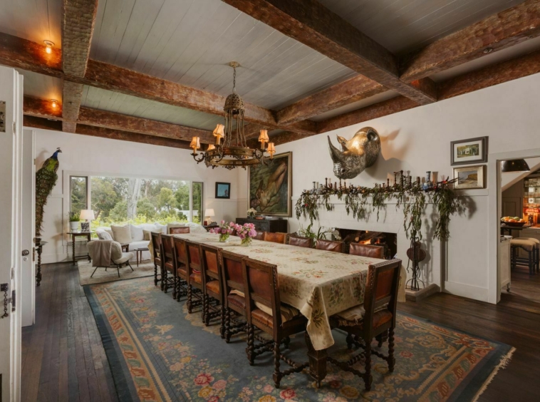 Large dinning are with white ceiling and hand hewn wood beams