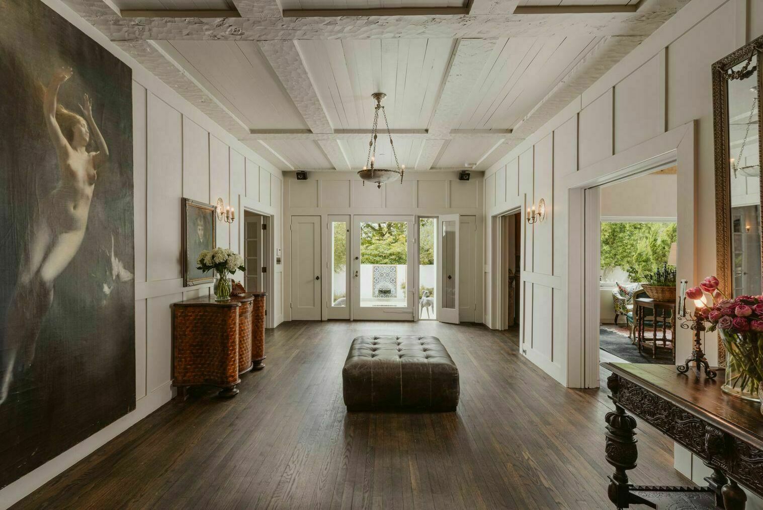 Large foyer with white hand hewn beams and dark hardwood floors