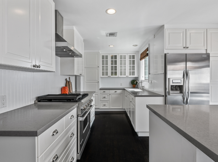 White cabinets with grey countertops and stainless appliances