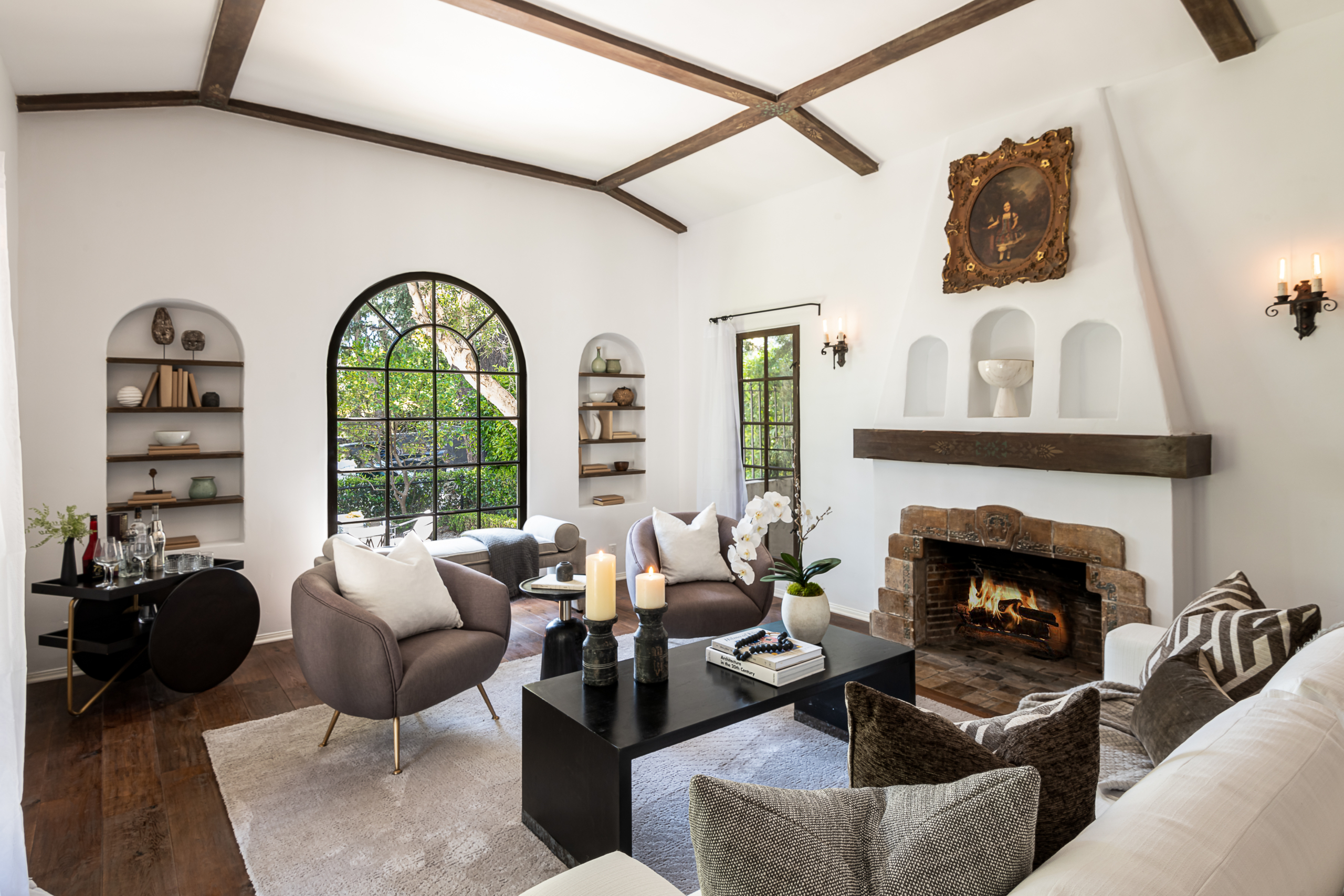 Large Spanish style living room with bright white walls and dark beams