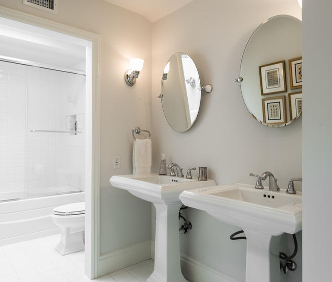 White bathroom with two pedestal sinks