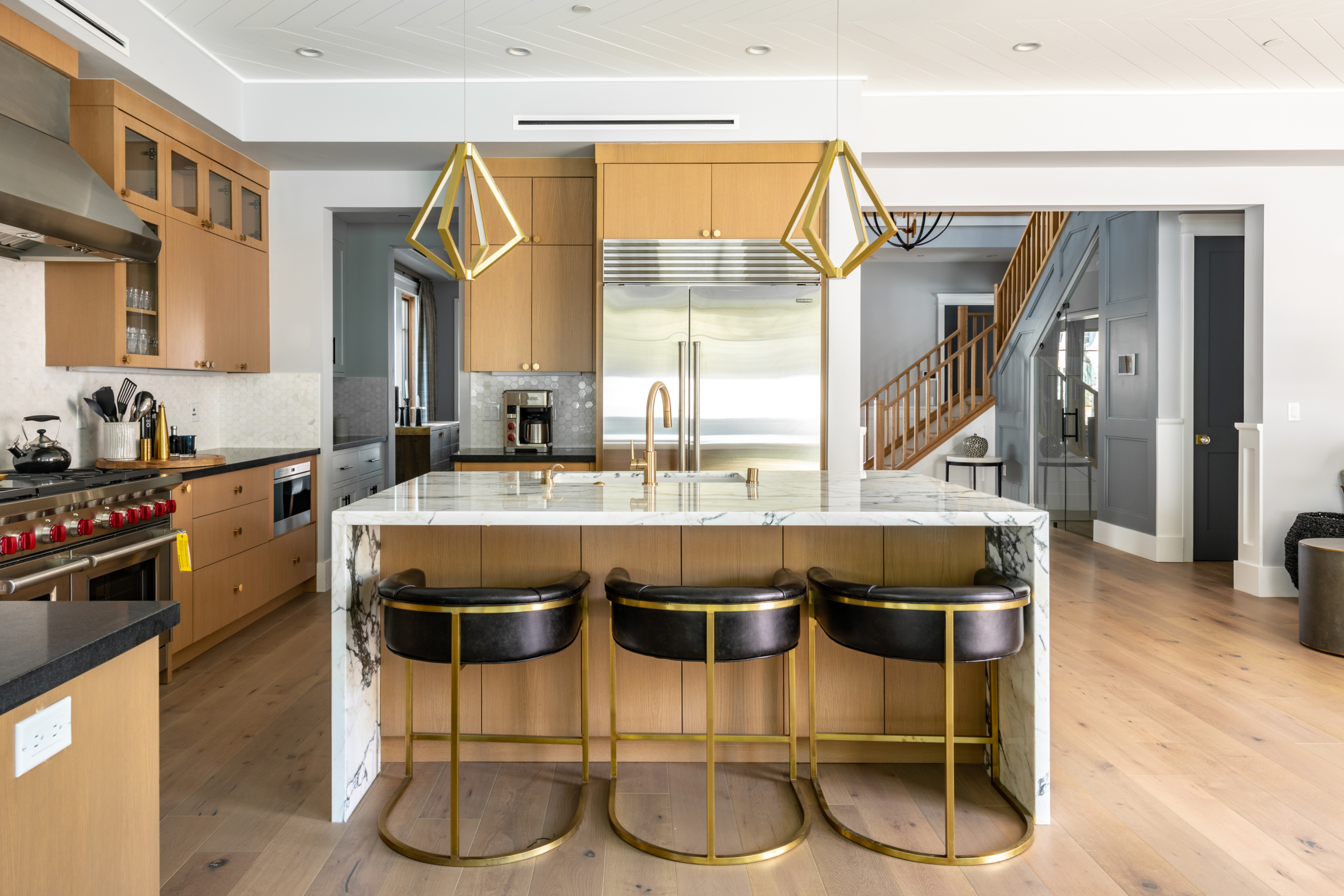 contemporary kitchen with marble wrapped breakfast bar, gold fixtures and upscale appliances