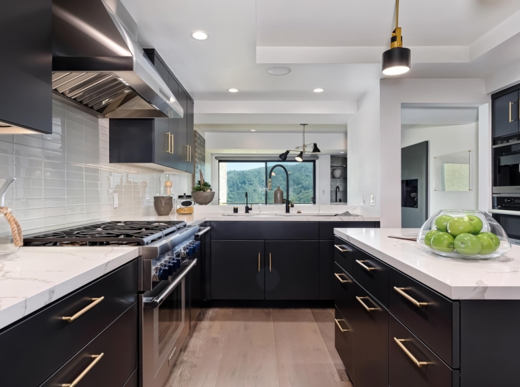 modern kitchen with white marble countertops, stainless and black appliances and black cabinets
