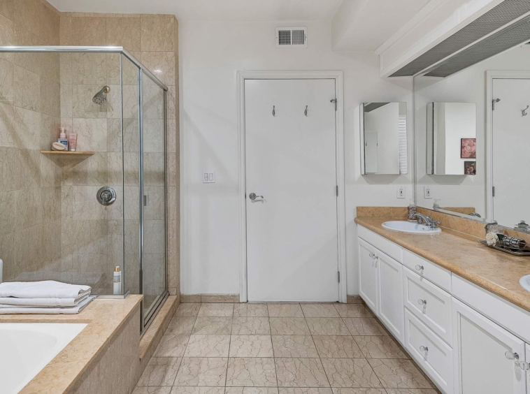 Oversized en-suite bath with dual vanity, soaking tub, and separate shower.