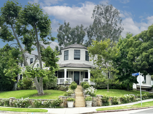 Pacific Palisades white and black traditional home on a corner lot with mature trees.